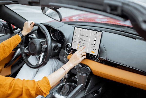 Telematics Insurance - Woman Controlling Her Car With a Digital Tablet and Switching to Autopilot While Driving on a Sunny Day