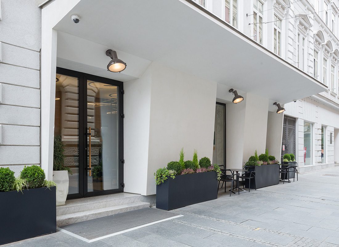 Insurance Solutions - Exterior View of the Front Entrance of a Luxury Hotel in the City with Vibrant Plants Outside